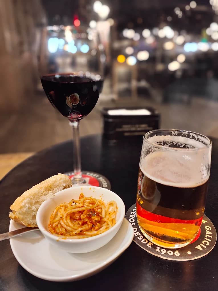 Cerveza, vino y una tapa sobre una mesa