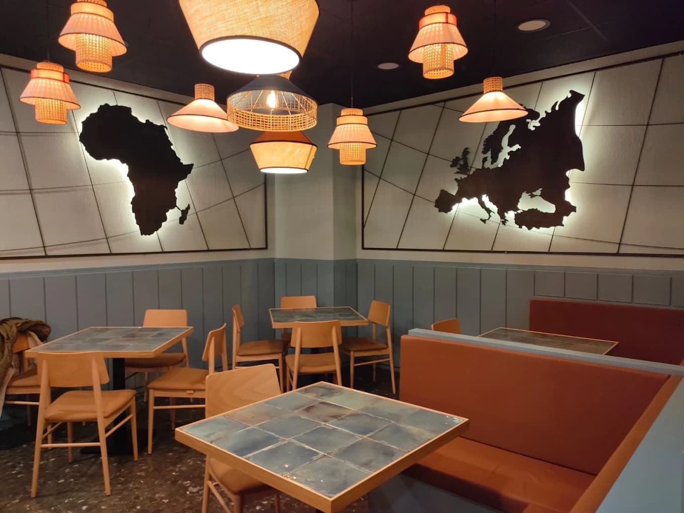 Interior de Atlas con iluminación cálida y mapas en las paredes